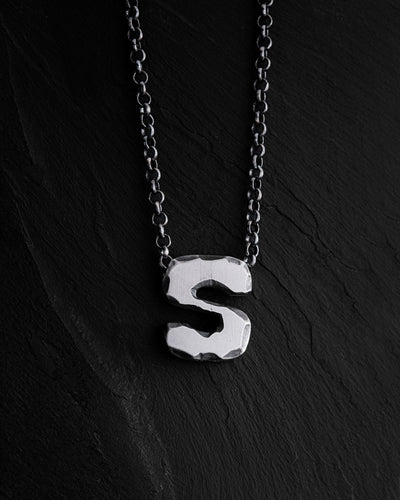 Anhänger mit dem Buchstaben S an einer Kette